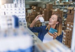Photo of brown hair women Ensuring deliveries in distribution warehouse. Perfect medication. Shot of a young beautiful pharmacist looking for an ordered drug on a shelf at the local pharmacy.